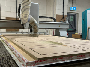 Image of CNC Router cutting wood for an Exhibition Stand with a text overlay saying Build. 