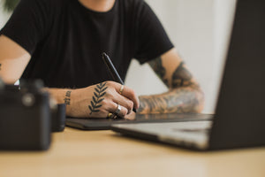 Image of Person Using a Pen Designing an Exhibition Stand with a text overlay saying Design. 