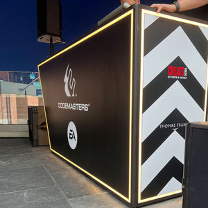 Angular DJ booth with Codemasters and EA branding and illuminated LED edging
